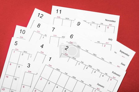 Foto de Muchas hojas de calendario mensuales en blanco sobre fondo rojo. - Imagen libre de derechos