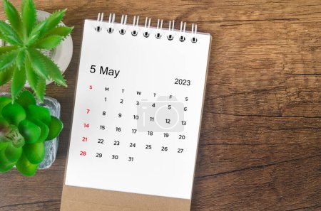 May 2023 desk calendar for 2023 on wooden background.