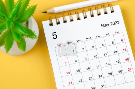 Foto de Mayo 2023 Calendario mensual de escritorio para 2023 con lápiz sobre fondo amarillo. - Imagen libre de derechos