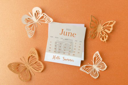 Téléchargez les photos : Bonjour été juin 2023 calendrier avec papier papillon sur fond de couleur orange. - en image libre de droit
