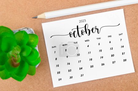 October 2023 Monthly calendar for 2023 year with wooden pencil on wooden table.