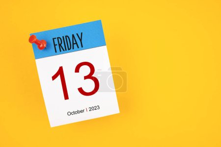 Photo for Calendar Friday the 13th October 2023 and push pin on yellow background. - Royalty Free Image