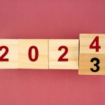 New year 2023 change to 2024. Flip over wooden cube block. New year resolution goal concept.