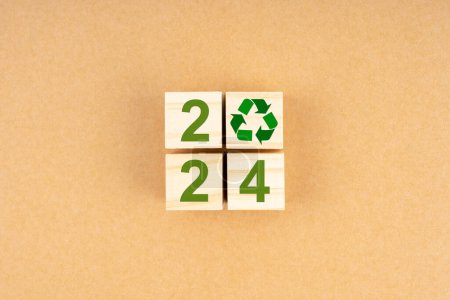 Téléchargez les photos : 2024 Nombres et symbole de recyclage sur cube en bois. Conservation de l'environnement et utilisation durable des concepts de responsabilité. - en image libre de droit