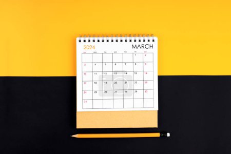 Téléchargez les photos : Vue du dessus du calendrier de bureau et du crayon de mars 2024 sur couleur jaune et noire. - en image libre de droit