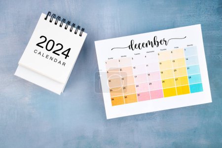 December 2024 calendar page with on blue wooden background.