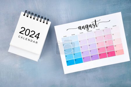 August 2024 calendar page on wooden background.