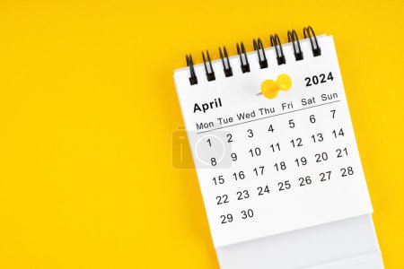 April 2024 Monthly desk calendar for 2024 year with thumbtack on yellow background.
