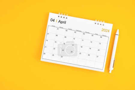 April 2024, Monthly desk calendar for 2024 year and pen on yellow color background.