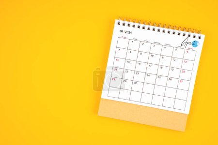 April 2024 desk calendar on yellow color background, position with copy space. 