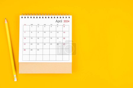 April 2024 desk calendar and wooden pencil on yellow color background. Time planning, day counting and holidays.