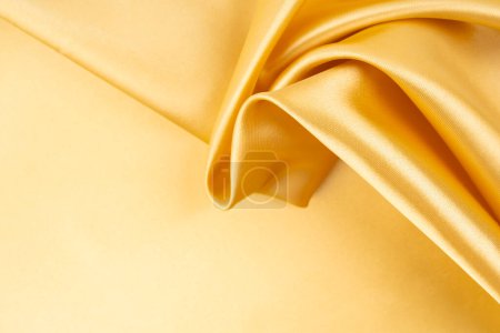 Textile de tissu de couleur dorée, fond abstrait.