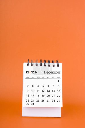 Foto de Vertical de diciembre 2024 calendario de la tabla sobre fondo de color naranja. - Imagen libre de derechos