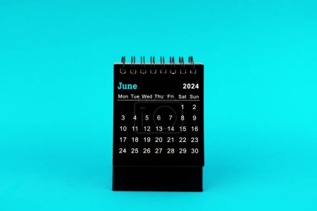 Foto de Calendario negro para junio de 2024. Calendario de escritorio sobre un fondo de color verde. - Imagen libre de derechos