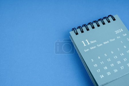 Foto de Noviembre 2024 calendario de escritorio sobre fondo de color azul. Copiar espacio. - Imagen libre de derechos
