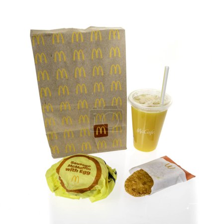 Photo for Winneconne, WI - 20 February 2024: A package of McDonalds breakfast including orange juice hashbrown and sausage egg cheese Mcmuffin on an isolated background. - Royalty Free Image