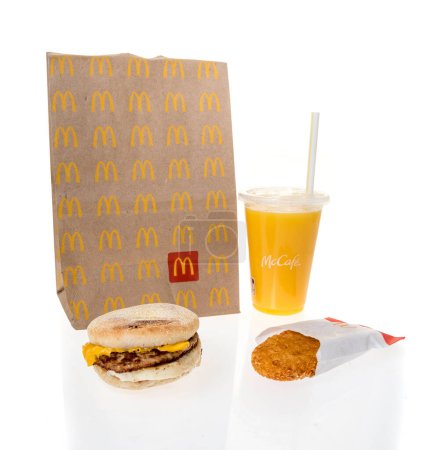 Photo for Winneconne, WI - 20 February 2024: A package of McDonalds breakfast including orange juice hashbrown and sausage egg cheese Mcmuffin on an isolated background. - Royalty Free Image