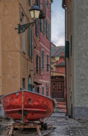 Urban Contrasts in Boccadasse. High quality photoA solitary boat rests on the cobblestoned path of Boccadasse, a picturesque district of Genoa.