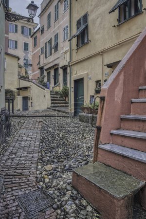 Stepping Through Boccadasse. High quality photoA meandering alley in Boccadasse adorned with pebbles and red brick steps.