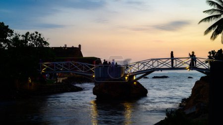 Photo for Galle butterfly bridge in Dharmapala park evening sunset, long exposure landscape shot. People taking photographs on the bridge. - Royalty Free Image
