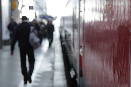 Travelers on a railway platform, focus on the foreground.
