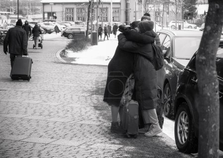 Photo for Two women are hugging each other in front of a train station. One of them is clearly heading for a train trip. - Royalty Free Image