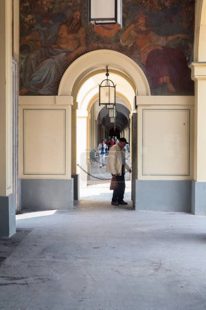 Photo for A senior man is standing in the archway of an old palace. He seems to be reading something written on the wall. - Royalty Free Image