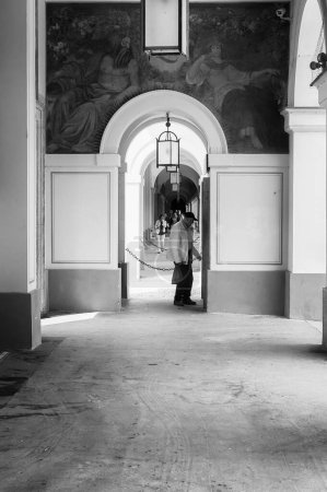 Photo for A senior man is standing in the archway of an old palace. He seems to be reading something written on the wall. - Royalty Free Image