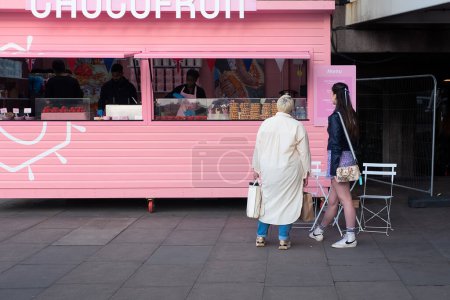 Photo for Two women are looking at the menu at the street food stand in London. - Royalty Free Image
