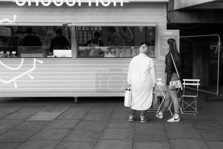 Photo for Two women are looking at the menu at the street food stand in London. - Royalty Free Image