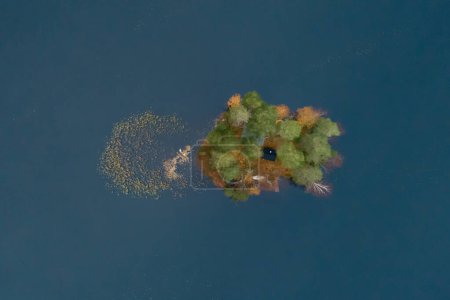Photo for A small island is in the middle of a lake. There's just space for a cabin and a boat. - Royalty Free Image