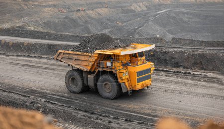 Großer Baggerkipper. Großer gelber Bergbaulastwagen auf der Baustelle. Kohle in Karosseriewagen verladen. Produktion nützlicher Mineralien. Bergbaumaschinen für den Transport von Kohle aus der Tagebauproduktion.