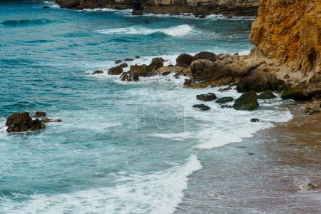 Photo for Surfers in the ocean. Panorama view of Praia do Tonel (Tonel beach) in Cape Sagres, Algarve, Portugal. Praia Do Tonel, beach located in Alentejo, Portugal. Ocean waves on Praia Do Tonel beach. View from Sagres fortress. - Royalty Free Image