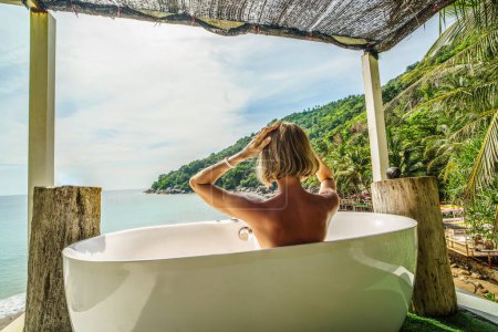 Foto de Sueño de viaje. Vista posterior de la mujer tomando un baño durante el amanecer en la costa. Hermoso paisaje. Tailandia. - Imagen libre de derechos