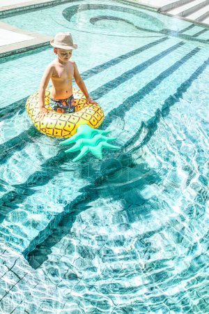 Téléchargez les photos : Enfant jouant dans la piscine par une journée ensoleillée d'été. Vacances et concept de vacances. Tourisme. - en image libre de droit