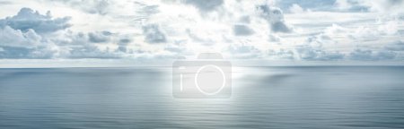 Foto de Foto de un horizonte donde el cielo con nubes y la superficie azul del mar se encuentran. Paisaje marino. Antecedentes Océano. - Imagen libre de derechos