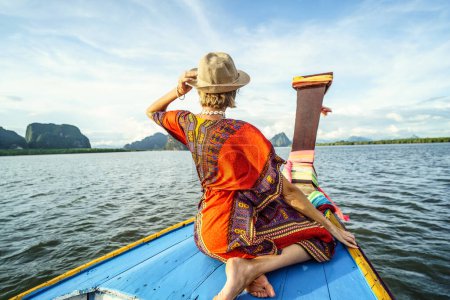 Téléchargez les photos : Voyage en bateau traditionnel à longue queue sur les îles tropicales en Thaïlande. Femme assise et relaxante, regardant le paysage. Vacances exotiques d'été en Asie. - en image libre de droit