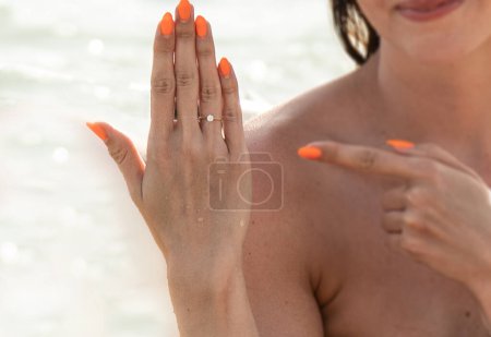 Foto de She said yes! Closeup photo of women's hand with diamond engagement ring on finger. Valentine's day concept. Love. Real people lifestyle. - Imagen libre de derechos