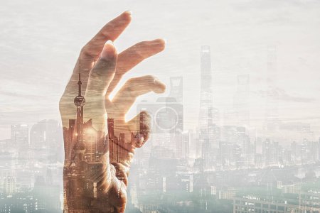 Téléchargez les photos : Conceptual photo of hand on a city background. High skyscrapers. Success. Business. Modern buildings. - en image libre de droit