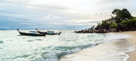 Téléchargez les photos : Coastal landscape at the tropical beach in Thailand. Long tail boats. Man meditating, relaxing. Morning light. - en image libre de droit
