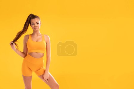 Foto de Happy fit Woman Over yellow Studio Background. Beautiful girl after Fitness Workout. Healthy lifestyle concept. A lot of copy space - Imagen libre de derechos