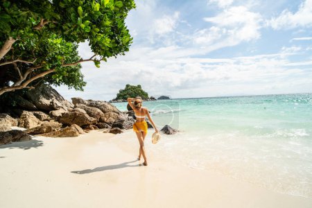 Téléchargez les photos : Summer vacation. Carefree joyful woman walking on white sand, relaxing and enjoying tropical beach. Traveler. Tourism. Wanderlust. - en image libre de droit