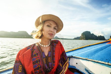 Foto de Travel tour by traditional long tail boat on tropical islands in Thailand. Woman relaxing, looking at the camera. Summer exotic holidays in Asia - Imagen libre de derechos