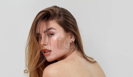 Photo for Beauty portrait of charming caucasian young woman with natural freckles on her face and shoulders. Girl looking at camera. Delicate elegant small earrings in ear. A lot of copy space - Royalty Free Image
