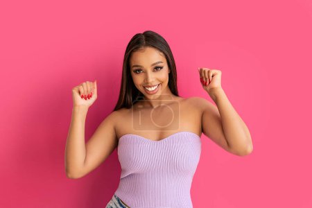 Photo for Joyful woman smiling, looking at the camera, posing on a pastel pink Studio Background. Real people emotions, toothy smile. Fashionable young girl, A lot of copy space. - Royalty Free Image