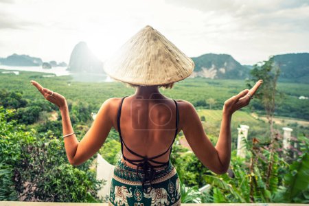 Téléchargez les photos : Voyageur femme appréciant Phang Nga Bay point de vue. Touriste à Samet Nang She, Thaïlande. Voyage en Asie, voyage et vacances d'été concept. Vue de derrière. La soif d'errance - en image libre de droit