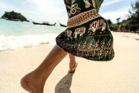 Foto de Foto de cerca de los pies de la mujer caminando en la playa de arena. Detalle. Asia. Tailandia. Vibras de verano. Viajero. - Imagen libre de derechos