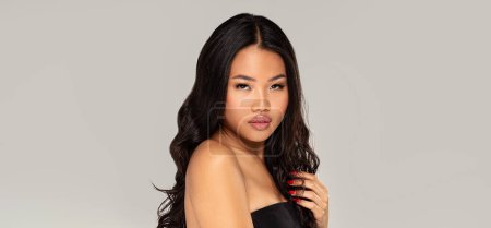 Téléchargez les photos : Portrait de beauté de femme asiatique sensuelle avec maquillage glamour posant sur fond de studio. La fille qui regarde la caméra. Beaucoup d'espace de copie. - en image libre de droit