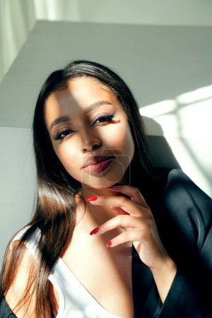 Photo for Beauty portrait of young mixed raced woman looking at the camera, posing in natural sunny light. Beautiful girl with long lashes. - Royalty Free Image