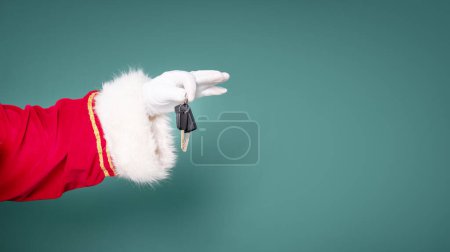 Foto de La mano de Santa Claus sostiene las llaves del coche como regalo de Navidad. - Imagen libre de derechos